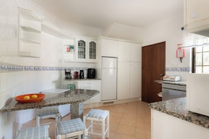 A kitchen with white cabinets, a granite countertop, a refrigerator, and a toaster. - Villa Ladeira - Private pool, Sea view, Smart tv, games, wifi, Ac (Albufeira)