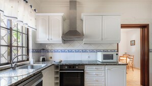A kitchen with white cabinets, a stainless steel range hood, a microwave, and a dishwasher. - Villa Ladeira - Private pool, Sea view, Smart tv, games, wifi, Ac (Albufeira)