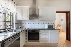 A kitchen with white cabinets, a stainless steel range hood, a microwave, and a dishwasher. - Villa Ladeira - Private pool, Sea view, Smart tv, games, wifi, Ac (Albufeira)
