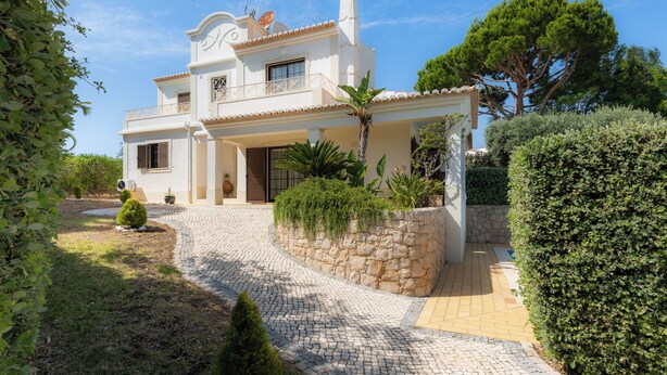 A two-story house with a stone pathway leading to the entrance, surrounded by greenery and a clear blue sky. - Villa Ladeira - Private pool, Sea view, Smart tv, games, wifi, Ac (Albufeira)