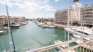 A marina with multiple boats docked, a lighthouse, and buildings with balconies. - Apartment with stunning views, 2 bedroom in the port of Empuriabrava (Empuriabrava)