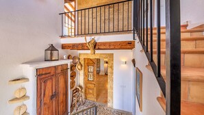 Un escalier en bois avec une rampe noire menant à un deuxième étage.