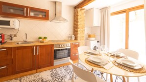 A kitchen with wooden cabinets, a microwave, a stove, and a dining area set for a meal.