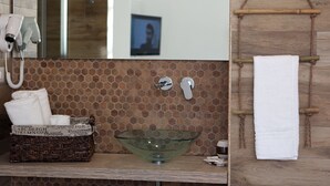 A bathroom with a glass bowl sink, a white towel, a hairdryer, and a wooden towel rack. - DIMORA DIAMANTE - ZAFFIRO ROOM                                    (Napoli)