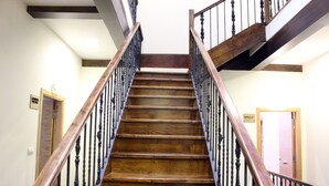 A wooden staircase with black balusters, leading to an upper floor.
