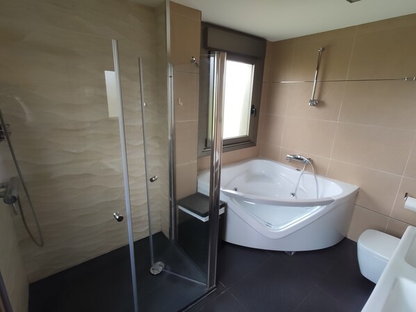 A modern bathroom with a glass-enclosed shower, a freestanding bathtub, and a toilet. - Design house with pool. (Sanxenxo)