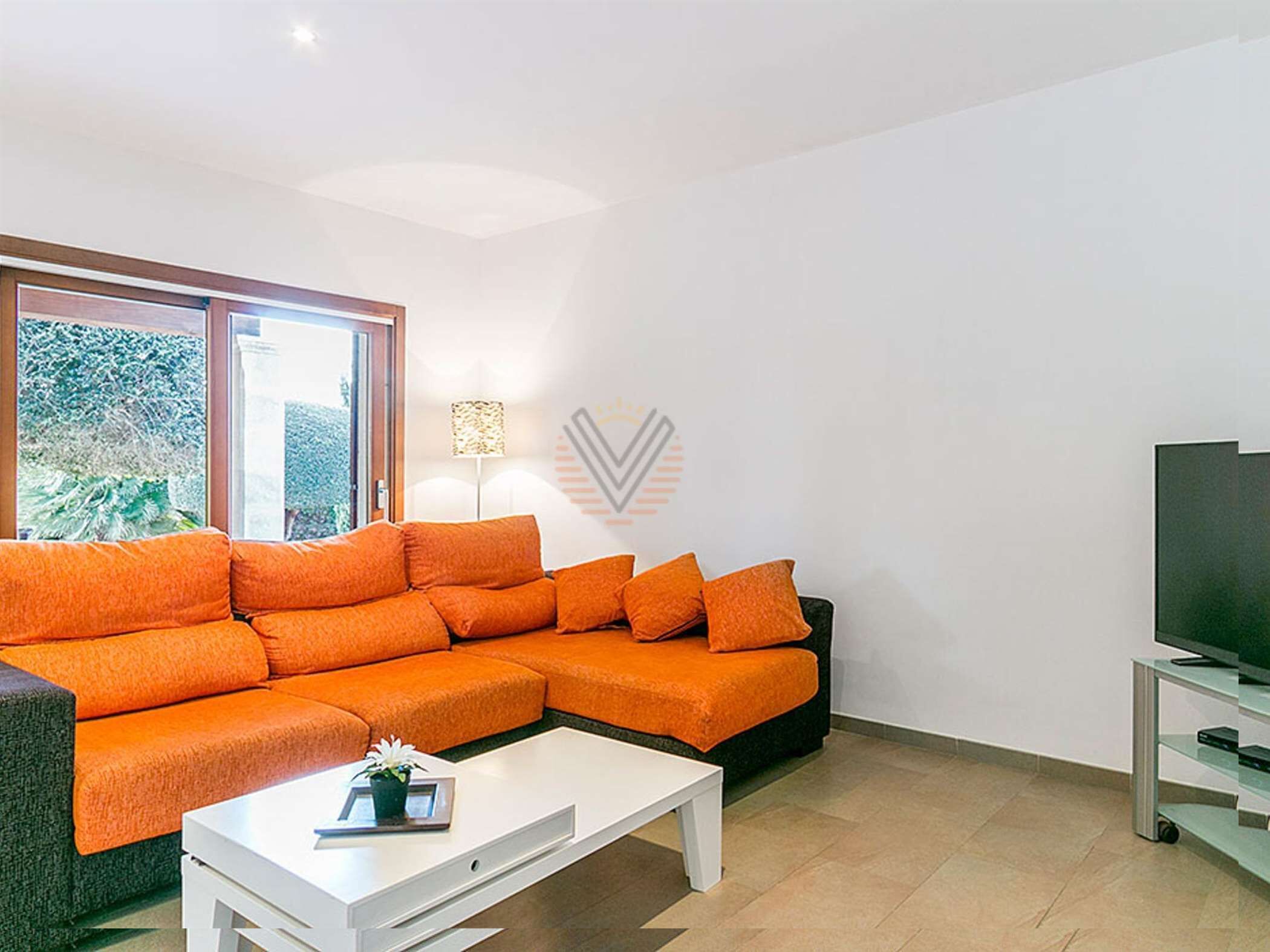 Een moderne woonkamer met een modulaire bank, een salontafel en een tv-meubel.