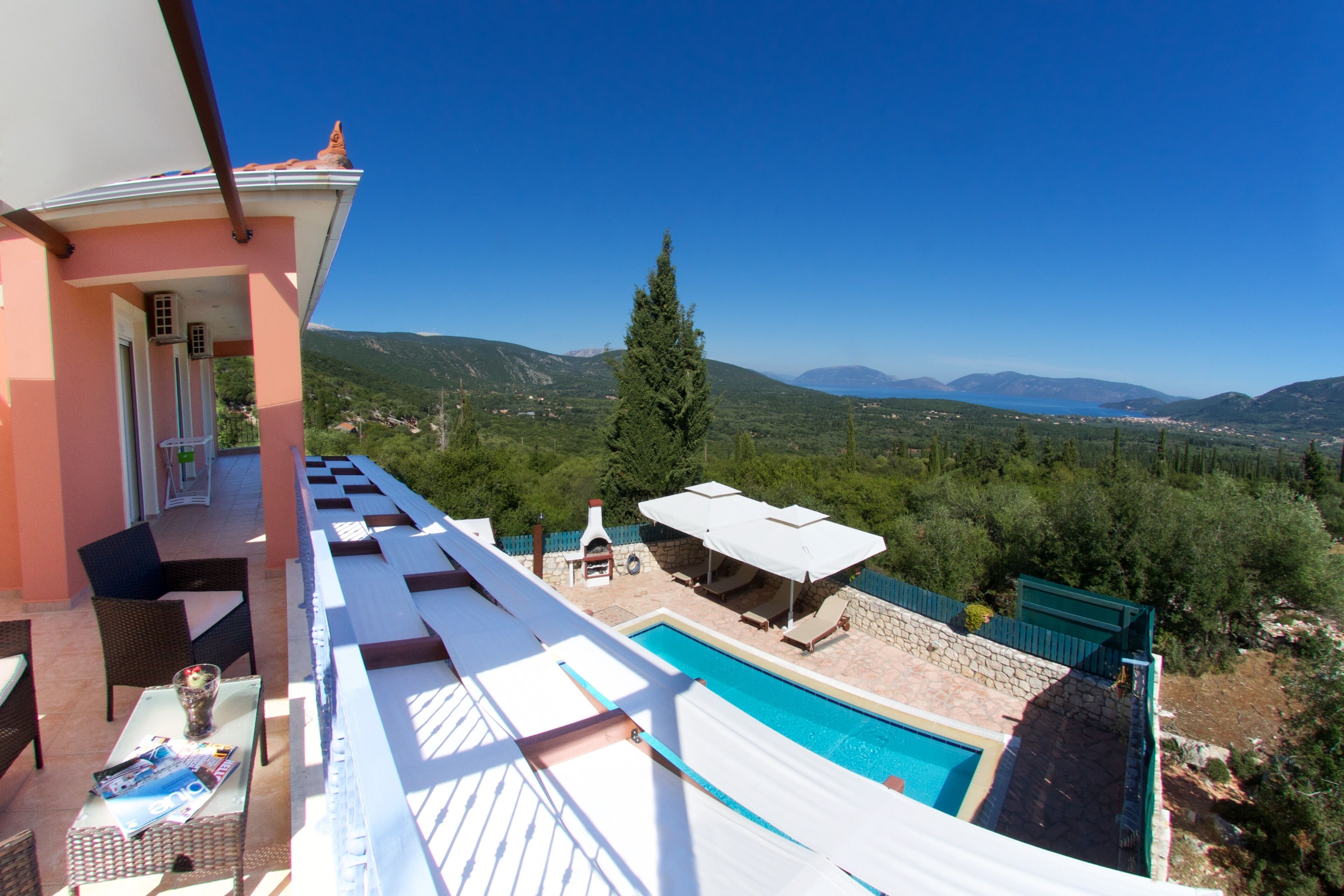Un balcón con piscina, mobiliario exterior y vistas a las montañas.