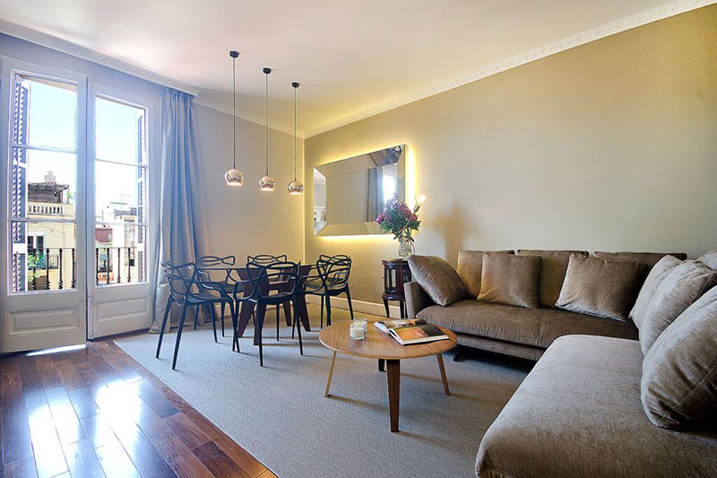 Un salon comprenant un canapé, des fauteuils, une table basse et un coin repas avec des chaises et une table.