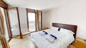 A hotel room with a bed, a chair, a nightstand, and a large mirror. - Apartment with Sea Views and Sunlit Terraces (Marbella)