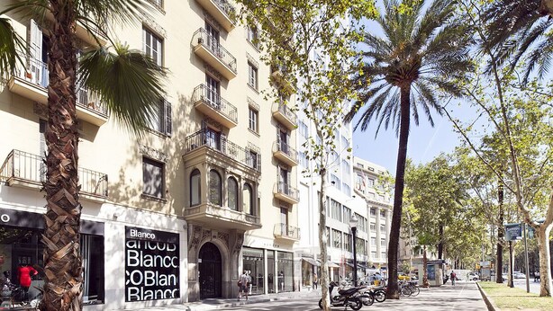 A street view with a building featuring balconies and a sign for 'Blanco'. - Three bedroom apartment Diagonal - You Stylish (Barcelona)