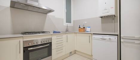 A compact kitchen with a Bosch gas stove, oven, and dishwasher, and a white refrigerator.