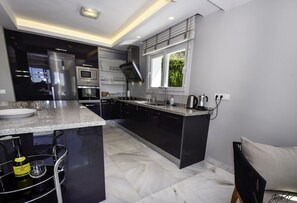 A modern kitchen with a central island, built-in appliances, and a window providing natural light.