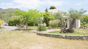 A residential area with a stone wall, a small shed, and a tree-lined pathway. - Sea view, terrace 20 m2, WIFI, parking, barbecue and garden of 1000 m2. (Roses, Girona)