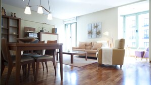 Amplia sala de estar con una mesa de comedor de madera, un sofá y una mesita de centro.