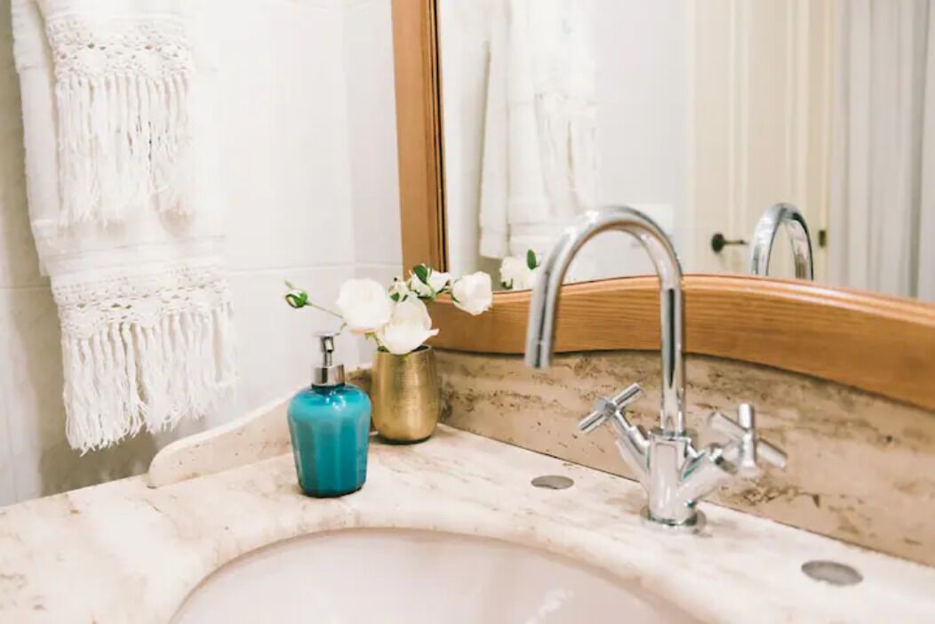 Une salle de bain équipée d’un lavabo, d’un miroir et d’un porte-serviettes.