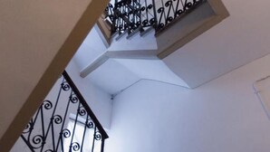 A spiral staircase with black railings and white walls.