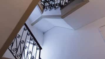 Eine Wendeltreppe mit schwarzen Geländern und weißen Wänden.