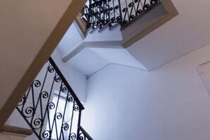 A spiral staircase with black railings and white walls.