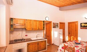 A kitchen with wooden cabinets, a sink, a stove, and a refrigerator.