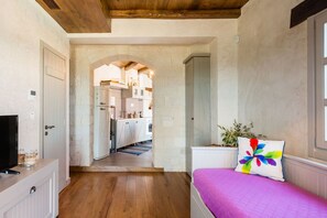 Une chambre avec un lit, une télévision et une vue sur un coin cuisine.