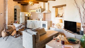 Ein gemütlicher Wohnbereich mit Sofa, Esstisch und einer Küche im Hintergrund.