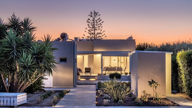 Ein modernes Haus mit Pool, Essbereich und gepflegtem Garten.