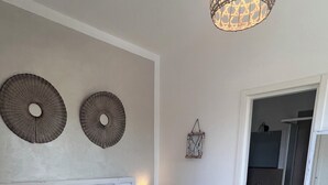 A bedroom with a large bed, a bedside lamp, and a wall-mounted light fixture.