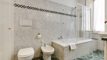 Tina con regadera, secadora de cabello, bidet, toallas