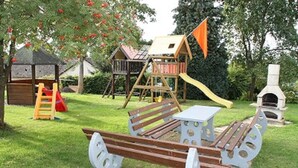 A playground with a slide, climbing structures, and a picnic table. - Haus Buchholz Apartment 3   (Liesenich)
