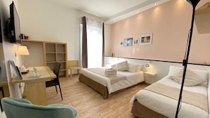 Una habitación de hotel con dos camas, un escritorio con silla, televisión y lámpara.
