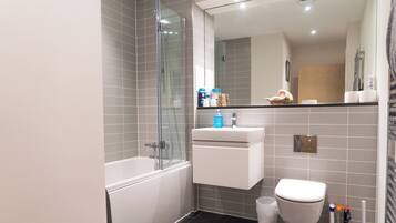 Une salle de bain moderne avec une baignoire, des toilettes et une douche à parois de verre.