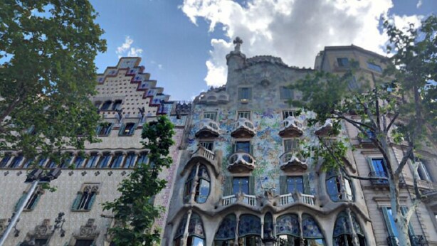 A building with unique architecture, featuring balconies, arched windows, and intricate designs.
