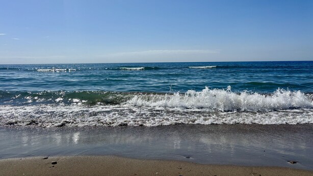 A beach with waves crashing onto the shore under a clear sky. - Apartment only 80 Meters from the Beach (Marbella)
