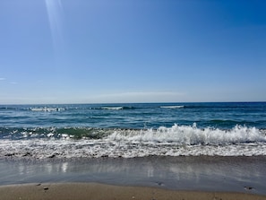 A beach with waves crashing onto the shore under a clear sky. - Apartment only 80 Meters from the Beach (Marbella)