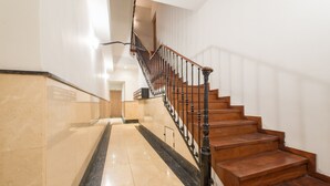 Una escalera de madera con balaustres negros que conduce a un piso superior.