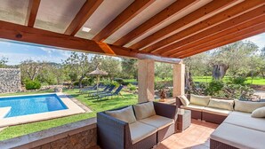 A covered outdoor area with a pool, wicker furniture, and a view of a garden. - Villa Tatoli is a spacious and traditional 4 bedroom villa with private pool (Pollensa)