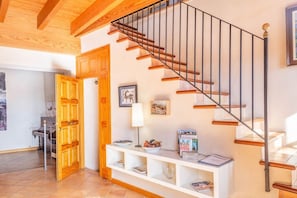 A staircase with wooden steps and metal railings, leading to a landing with a white console table and a framed picture. - Townhouse In Palma 300 mts from the Beach (Palma)