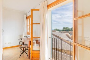A room with a view of a stone wall and a metal railing outside.