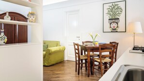 Un coin repas avec une table en bois, des chaises et un canapé vert.