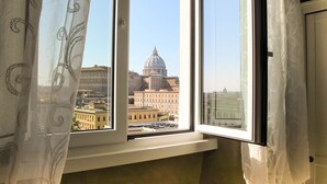 A window with a view of a cityscape, including a prominent dome building.