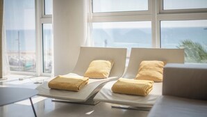A room with two reclining chairs, each with a yellow pillow and a folded towel. - Sea view three bedroom apartment - You Stylish (Barcelona)