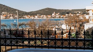 A hot tub with a view of a coastal town and hills in the background. - Seafront app with jacuzzi and huge terrace (Vinišće)