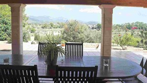 A covered outdoor dining area with a view of a mountainous landscape. - Finca Can Mirlo in en Santa Maria (Marratxi)