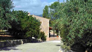 A stone building with a stone pathway leading to a covered area. - Finca Can Mirlo in en Santa Maria (Marratxi)