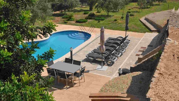 A swimming pool with a sun terrace, surrounded by greenery and hills. - Finca Can Mirlo in en Santa Maria (Marratxi)