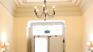Entrada de un hotel con un candelabro, un letrero que dice "SALIDA" y un felpudo.