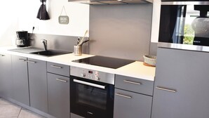 Una cocina moderna con lavavajillas Bosch, un lavabo doble y un refrigerador de acero inoxidable.