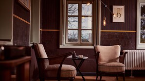 A cozy room with two wooden chairs, a small table with a teapot, and a window with a view of trees. - Large, lovingly renovated half-timbered house with sauna & garden (Ebersbach-Neugersdorf)
