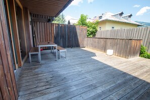 A wooden deck with a table and benches, surrounded by a wooden fence.